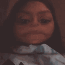a close up of a girl making a funny face with her eyes closed .
