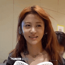 a close up of a woman 's face with yunjin written on the bottom
