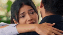 a man and a woman are hugging each other . the woman is crying and the man is holding her .