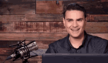 a man is smiling in front of a microphone