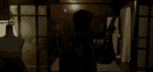 a man is holding a gun in a dark room in a room .