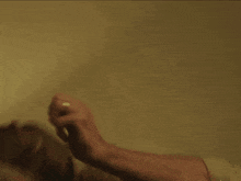 a woman is holding a gun in her right hand and pointing it at the camera .