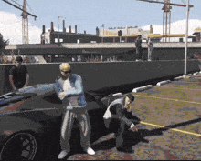 a man in a blue jacket is standing in front of a black car