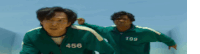 two men in green jackets with the numbers 456 and 199 on them are running in a race .