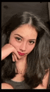 a close up of a woman with her hand on her face