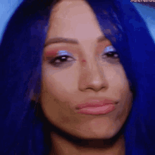 a close up of a woman with blue hair making a funny face