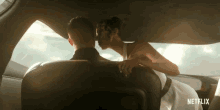 a man and woman kissing in the back seat of a car with netflix written on the bottom right