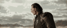 a man in a superhero costume is standing in the middle of a desert .
