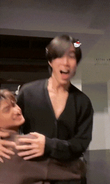 two men are hugging each other and one has a hello kitty on his head