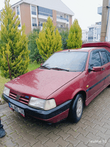a red car with a license plate that says 54 ak0 128 is parked on a brick sidewalk