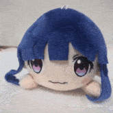 a stuffed animal with blue hair and pink eyes is displayed on a white background
