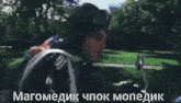 a man wearing a helmet and goggles is sitting on a motorcycle in a park ..