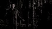 a man in a suit and tie is holding a bloody hand in the dark