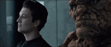 a man in a black shirt is standing next to a statue of the thing