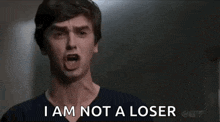 a man is screaming with his mouth open and the words `` i am not a loser '' .