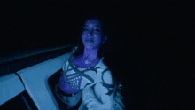 a woman with purple paint on her face is sitting in a white car