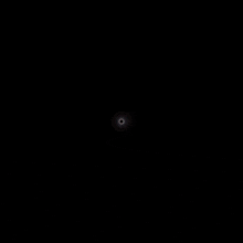 a white circle with a black center on a black background