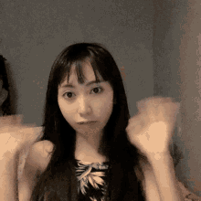 a woman with long black hair is making a funny face
