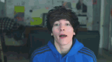 a boy in a blue hoodie is giving the middle finger with the words hey guys behind him