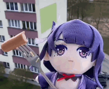a stuffed doll is holding a sausage on a fork in front of a building .