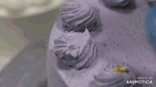 a cake with purple frosting and gold sprinkles is being made in animatica
