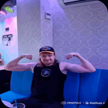 a man is flexing his muscles in front of a wall that says minimx on it