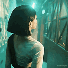 a woman with short hair is standing in a hallway