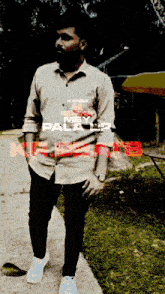 a man wearing a kanda shirt is standing on a path