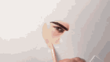 a close up of a person drawing a man 's eye with a pencil