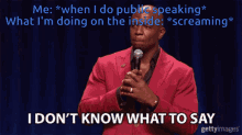 a man in a red suit holds a microphone and says i don t know what to say