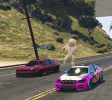 two cars are driving down a road with a sign that says justmelo in the background