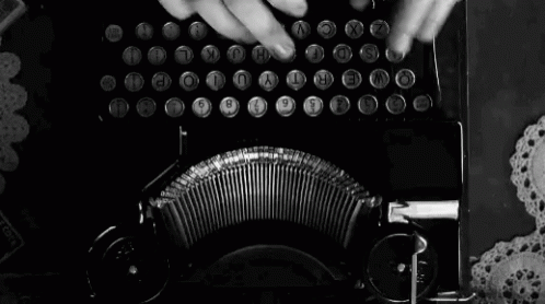 a black and white photo of a person typing on a typewriter with the letters t y and u visible