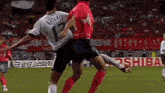 two men are playing soccer on a field and one of them has the number 13 on his jersey .