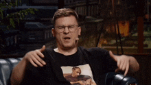 a man wearing a black shirt with a picture of snoop dogg on it is making a funny face