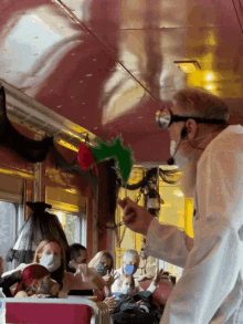 a man wearing goggles and a mask stands in front of a crowd