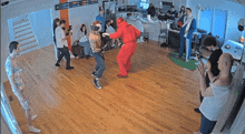 a group of people are gathered in a living room including a man in a red devil costume
