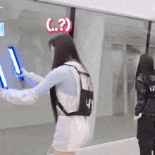 a woman holding a light stick with a question mark on her head