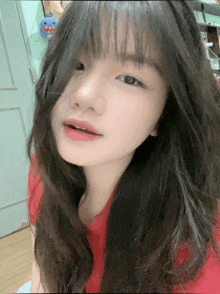 a close up of a girl 's face with a red shirt