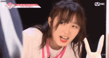 a girl in a white shirt is making a funny face while holding a bunny glove .