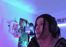 a woman wearing headphones is standing in front of a wall with pictures on it and a t-shirt that says daf