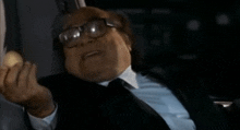 a man in a suit and tie is holding something in his hand .