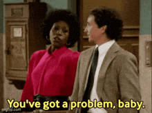 a man and a woman are standing next to each other and the woman says you 've got a problem baby .