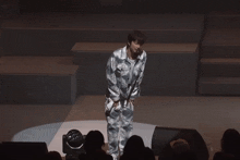 a man stands on a stage in front of a crowd