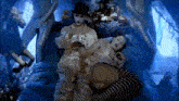 a couple of people laying on a bed with one wearing a hat
