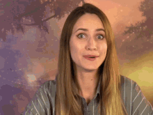 a woman wearing a striped shirt is making a surprised face