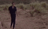 a man standing next to a pile of dirt that says football tm