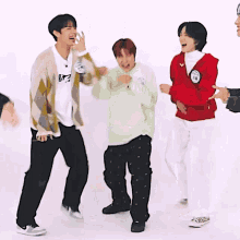 a group of young men are dancing together and one of them is wearing a sweater that says ' bts ' on it