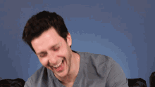 a man is laughing with his eyes closed