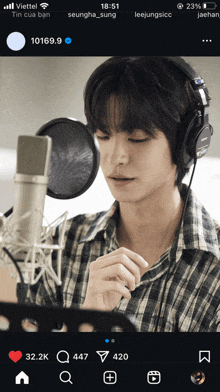 a man wearing headphones is singing into a microphone on a cell phone