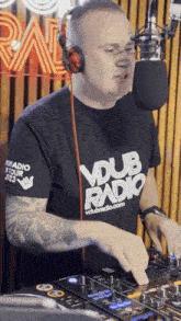 a man wearing headphones and a vdub radio shirt mixes music
